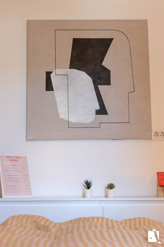 pictura decrativa abstracta cu fundal crem si forme abstracte cu alb si negru in context de dormitor amenajare wabi sabi